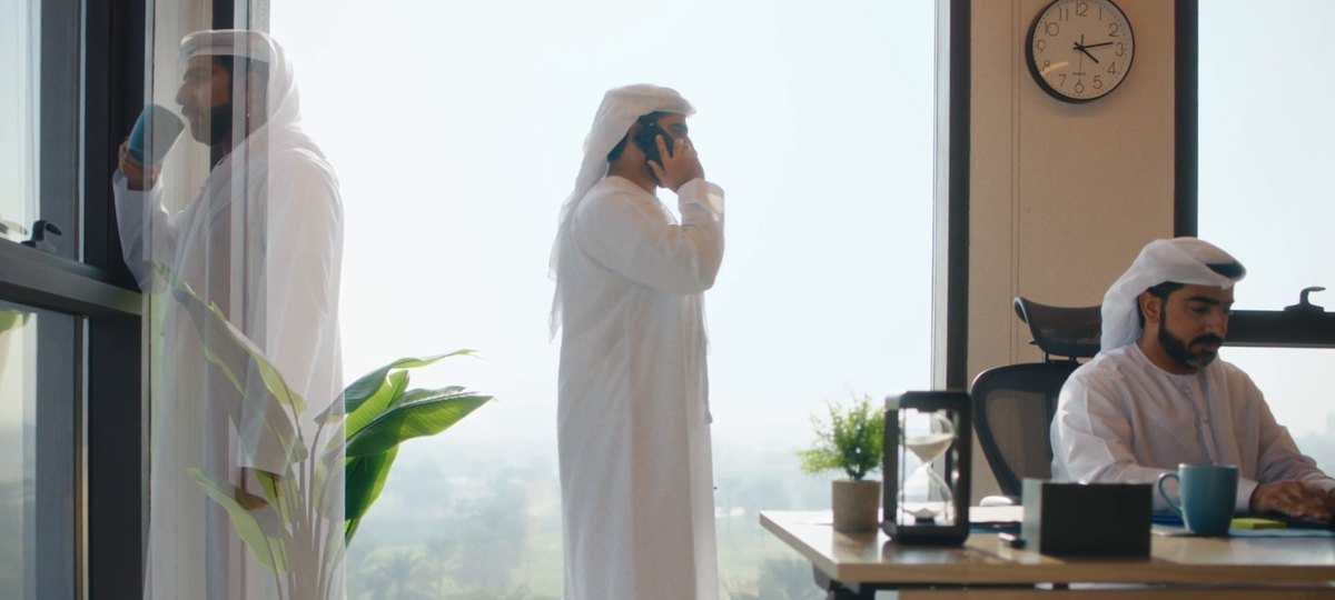 Three Emirati colleagues in a bright office