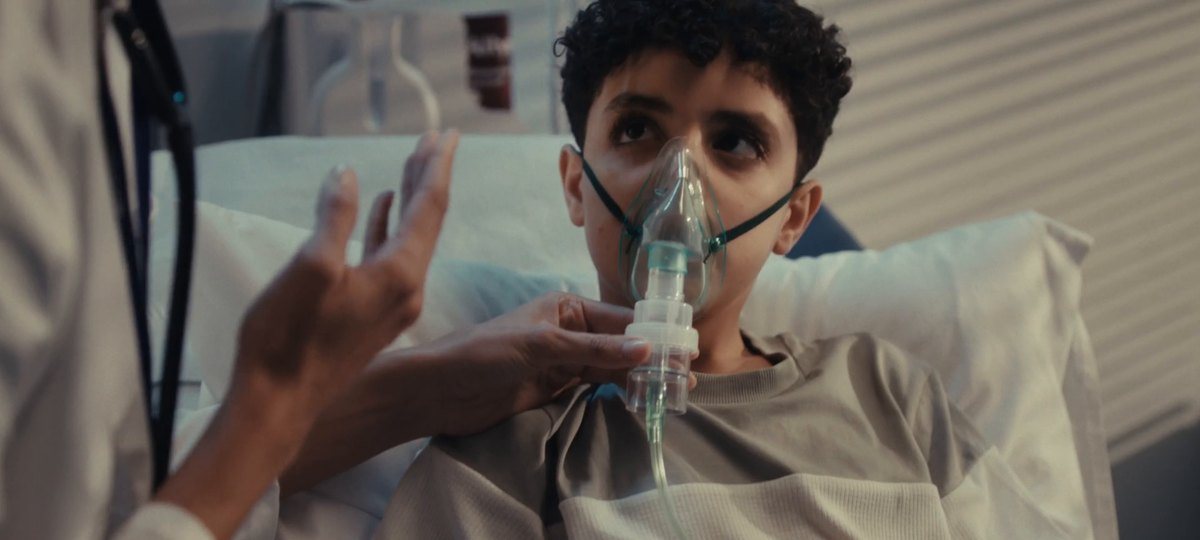 Young patient with an oxygen mask in a hospital bed