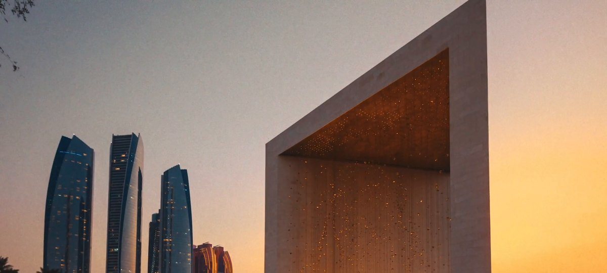 Abu Dhabi skyline beside the Founder’s Memorial at dusk